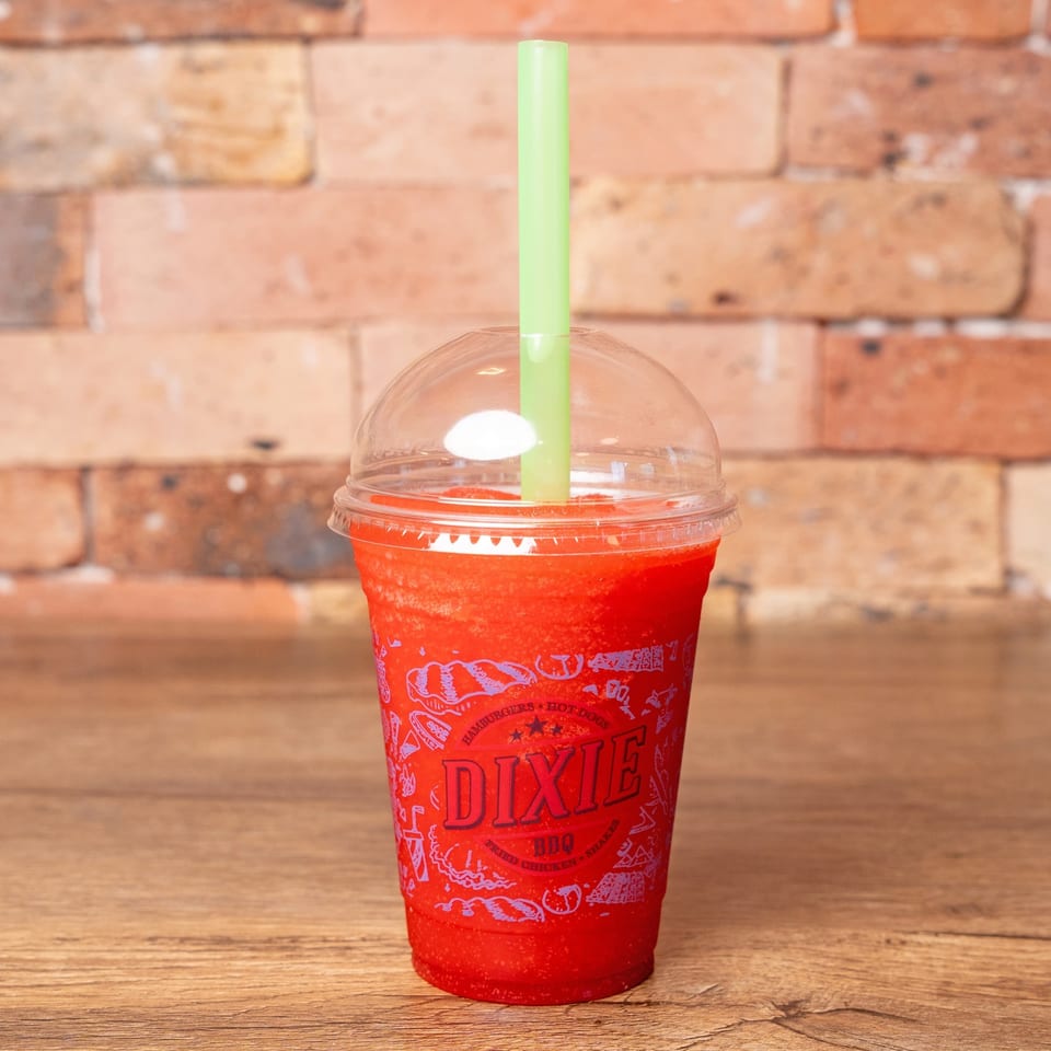 A Dixie BBQ branded cup filled with a red frozen drink and a green straw.